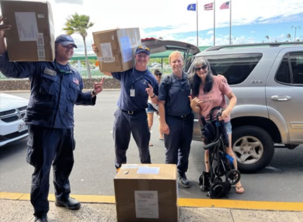 Ivana holding boxes of Medical Supplies with Emergency services workers