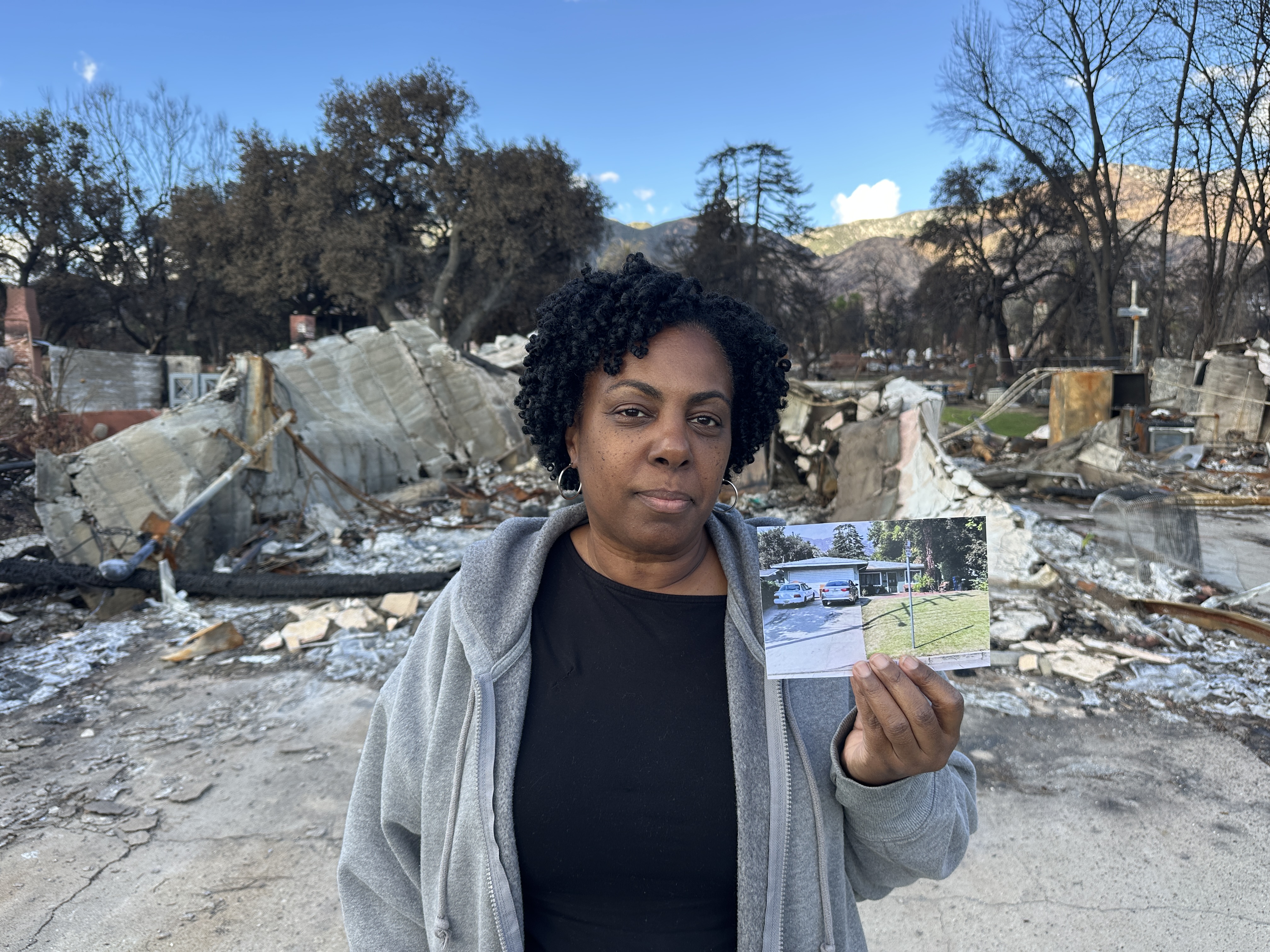 A woman holding a picture of what the assissted facility she runs used to look like before the Eaton Fire